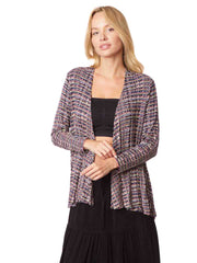 Woman wearing a black top and long black skirt with a patterned cardigan 